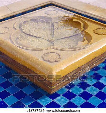 Picture - Close-up of small blue tiled pool with flower shaped marble fountain. Fotosearch