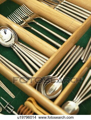 Picture - Close-up of stainless-steel cutlery in wooden storage drawer. Fotosearch