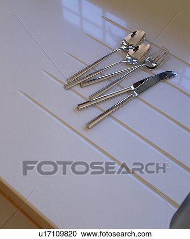 Close-up of stainless steel cutlery on white Corian worktop View Large Photo Image Stock Image - Close-up of stainless steel cutlery on white Corian worktop. Fotosearch