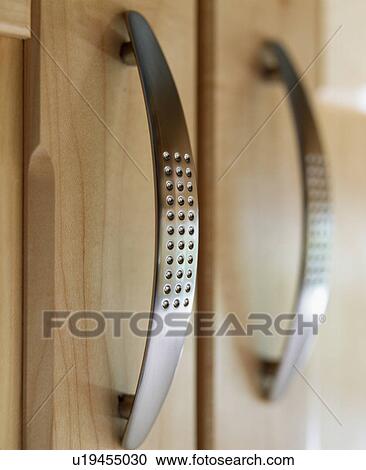 Stock Image - Close-up of stainless-steel drawer handles. Fotosearch