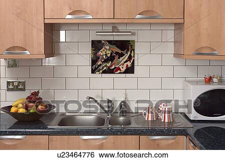 Stock Photograph - Close-up of stainless steel hob below fitted kitchen cupboard. Fotosearch