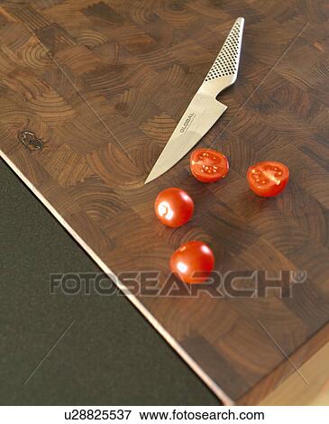 Stock Photo - Close-up of stainless steel kitchen knife with tomatoes on worktop. Fotosearch