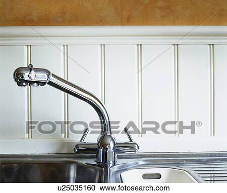 Stock Image - Close-up of stainless steel mixer tap. Fotosearch