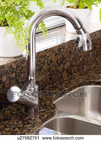 Stock Image - Close-up of stainless steel mixer tap. Fotosearch