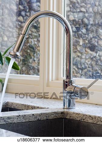 Close-up of stainless steel mixer-tap pouring water into underset sink View Large Photo Image Stock Photo - Close-up of stainless steel mixer-tap pouring water into underset sink. Fotosearch