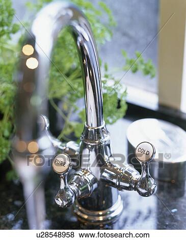 Stock Photo - Close-up of stainless steel mixer tap. Fotosearch