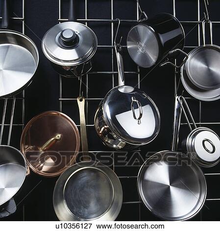 Stock Photo - Close-up of stainless steel saucepans on metal storage rack. Fotosearch