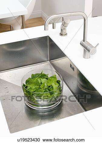 Close-up of stainless steel tap above salad leaves in glass bowl in stainless steel sink View Large Photo Image Stock Image - Close-up of stainless steel tap above salad leaves in glass bowl in stainless steel sink. Fotosearch