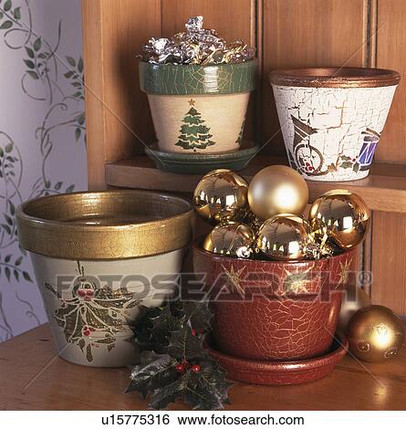 Stock Photograph - Close-up of stencilled flower-pots with gold Christmas baubles. Fotosearch