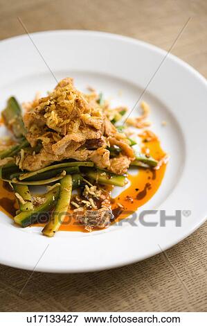Stock Photo - Close-up of stir-fried chicken with sliced courgettes. Fotosearch