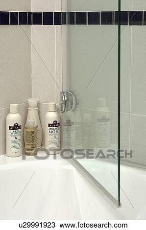 Close-up of toiletries on bath with glass shower door View Large Photo Image Stock Image - Close-up of toiletries on bath with glass shower door. Fotosearch