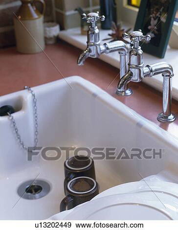 Close-up of traditional chrome taps and white Belfast sink View Large Photo Image Stock Photo - Close-up of traditional chrome taps and white Belfast sink. Fotosearch