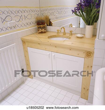 Stock Image - Close-up of underset basin in pine vanity unit. Fotosearch