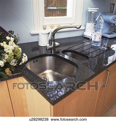 Stock Photo - Close-up of underset stainless steel sink in granite worktop. Fotosearch
