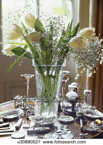 Close-up of vase of yellow tulips on table with collection of silver View Large Photo Image Stock Photo - Close-up of vase of yellow tulips on table with collection of silver. Fotosearch