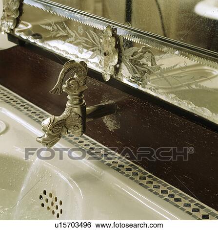 Stock Photograph - Close-up of Venetian mirror and ornate tap. Fotosearch
