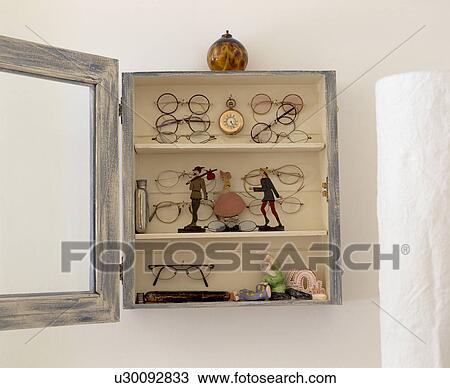 Close-up of wall-cupboard swith collection of figures and old spectacles View Large Photo Image Stock Image - Close-up of wall-cupboard swith collection of figures and old spectacles. Fotosearch