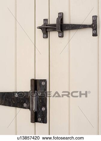 Stock Image - Close-up of white cottage bedroom door with black cast-iron latch and hinge. Fotosearch