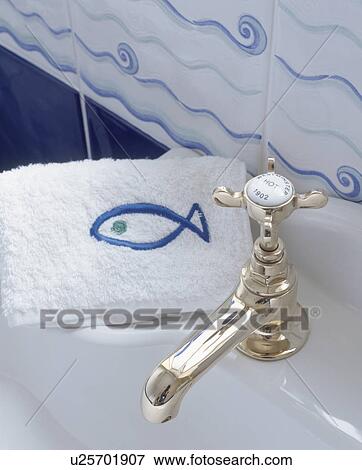 Close up of white flannel with blue fish motif beside chrome tap View Large Photo Image Stock Photo - Close up of white flannel with blue fish motif beside chrome tap. Fotosearch