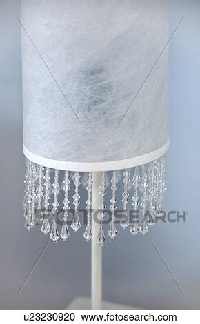 Stock Image - Close-up of white lamp with bead fringeing. Fotosearch