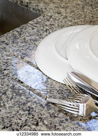 Close-up of white plates and stainless-steel cutlery on grey granite worktop View Large Photo Image Stock Photography - Close-up of white plates and stainless-steel cutlery on grey granite worktop. Fotosearch