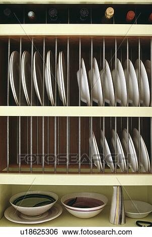 Stock Photograph - Close-up of white plates on cream plate rack. Fotosearch