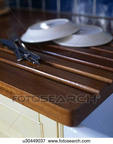 Close-up of white plates on Iroko wood draining board View Large Photo Image Stock Photo - Close-up of white plates on Iroko wood draining board. Fotosearch