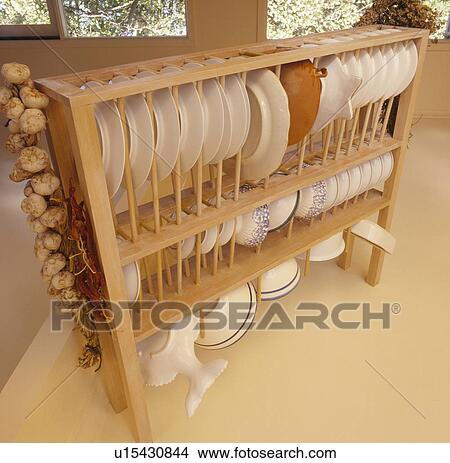 Picture - Close-up of white plates on suspended wooden rack. Fotosearch