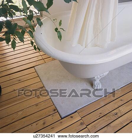 Close Up Of White Shower Curtain And Rolltop Bath On Marble And