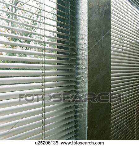 Stock Photograph - Close-up of white slatted blind on large window. Fotosearch