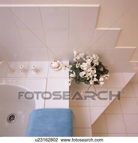 Stock Image - Close-up of white tiles on bath surround. Fotosearch