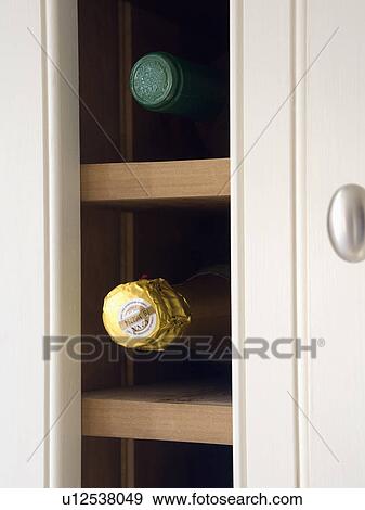 Stock Photo - Close-up of wine bottles on shelves in storage cupboard. Fotosearch
