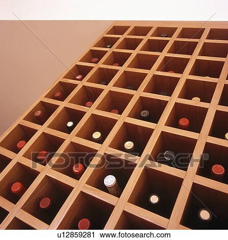 Stock Image - Close-up of wine stored in wooden rack. Fotosearch