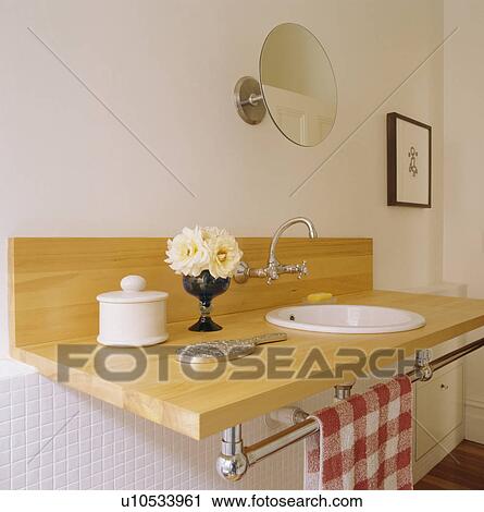 Stock Image - Close-up of wood vanity shelf with built-in basin. Fotosearch