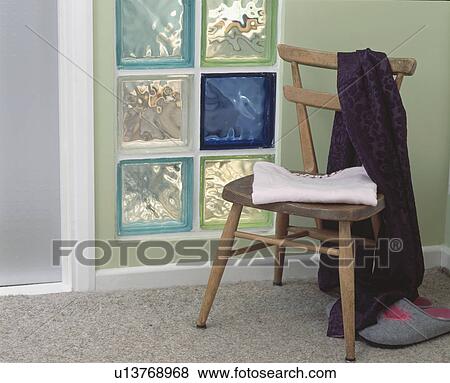 Clothes on old wooden chair in front of green and blue glass bricks in pastel green wall View Large Photo Image Stock Photo - Clothes on old wooden chair in front of green and blue glass bricks in pastel green wall. Fotosearch