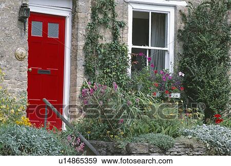 Colourful flower bed in front of window of cottage with red front door View Large Photo Image Stock Photo - Colourful flower bed in front of window of cottage with red front door. Fotosearch