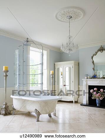 Stock Photograph Of Combined Clawfoot Bath And Shower In Pale Blue Combined Clawfoot Bath And Shower In Pale Blue Bathroom With White Ceramic Floor Tiles Gl Chandelier