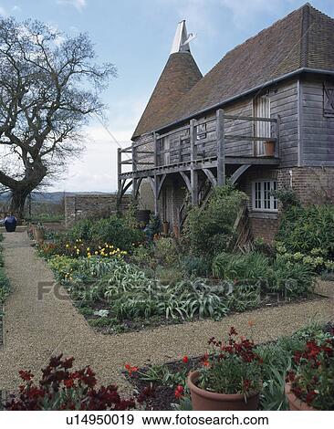 Converted oast house with wooden balcony and garden with gravel paths View Large Photo Image Stock Photo - Converted oast house with wooden balcony and garden with gravel paths. Fotosearch