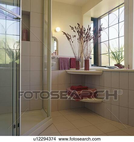 Picture - Corner shower cabinet and pink towels in modern white bathroom. Fotosearch