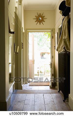 Stock Photo - Country hall with wooden flooring and open door with view of garden. Fotosearch