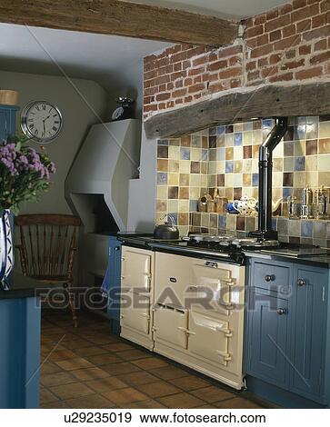 Stock Photo - Cream Aga oven in traditional blue country kitchen. Fotosearch