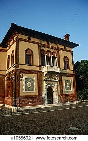 Stock Image - Cream and brown Venetian house with balcony above Palladian style front door onto street&#10;. Fotosearch