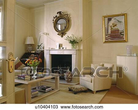 Cream armchair beside fireplace in traditional cream townhouse living room View Large Photo Image Stock Image - Cream armchair beside fireplace in traditional cream townhouse living room. Fotosearch