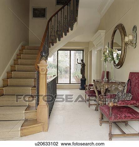 Stock Image - Cream carpet on staircase in traditional hall with white flooring. Fotosearch