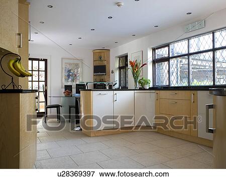 Stock Photo - Cream ceramic floor tiles in modern country kitchen dining room. Fotosearch
