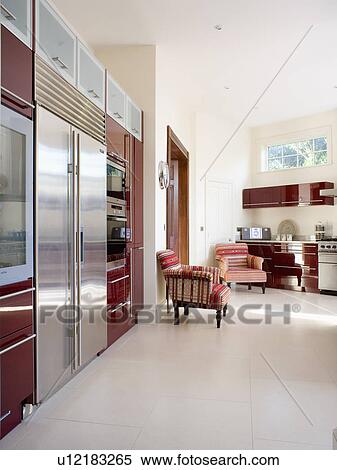 Stock Photography - Cream flooring in large modern country kitchen with stainless steel fridge freezer . Fotosearch