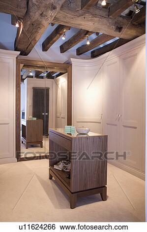 Cupboard in centre of dressing room with beamed ceiling and fitted wardrobes View Large Photo Image Stock Photograph - Cupboard in centre of dressing room with beamed ceiling and fitted wardrobes. Fotosearch