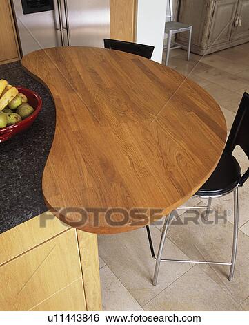 Stock Photograph - Curved wooden breakfast bar in modern kitchen. Fotosearch
