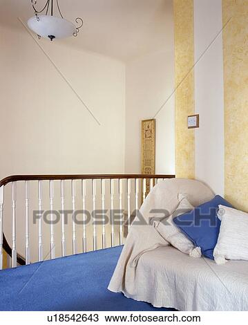 Cushions and beige throw on sofa on landing with blue carpet View Large Photo Image Stock Image - Cushions and beige throw on sofa on landing with blue carpet. Fotosearch