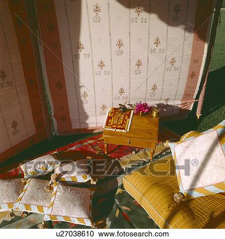 Stock Image - Cushions and small wooden table on floor of traditional Rajastani tent. Fotosearch